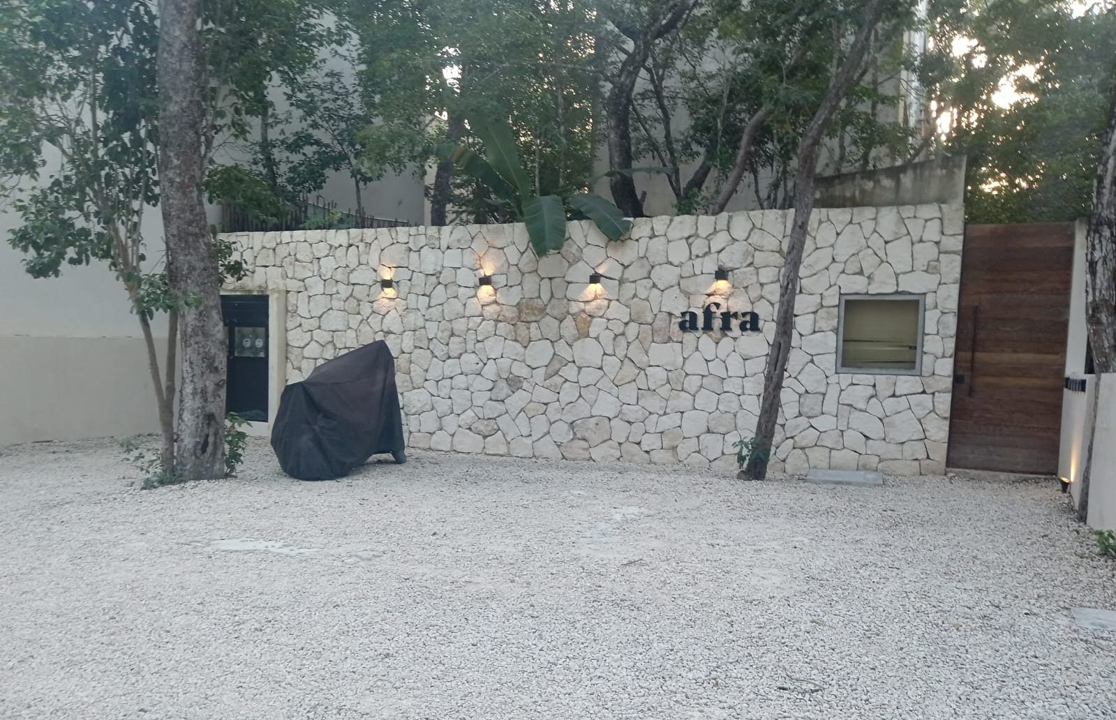 Muro de piedra de la entrada de Afra con su letrero
