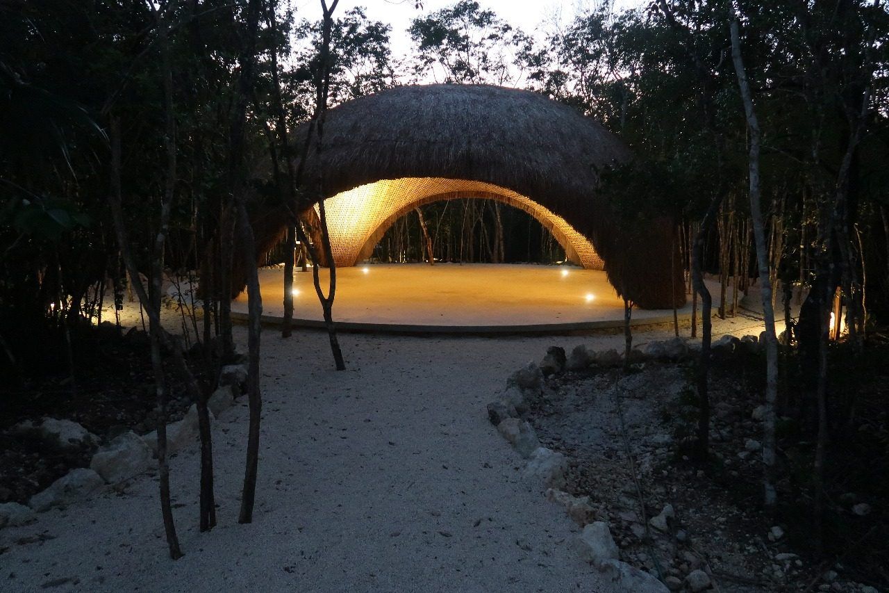 Palapa de Beecheii iluminada de noche, entre la selva
